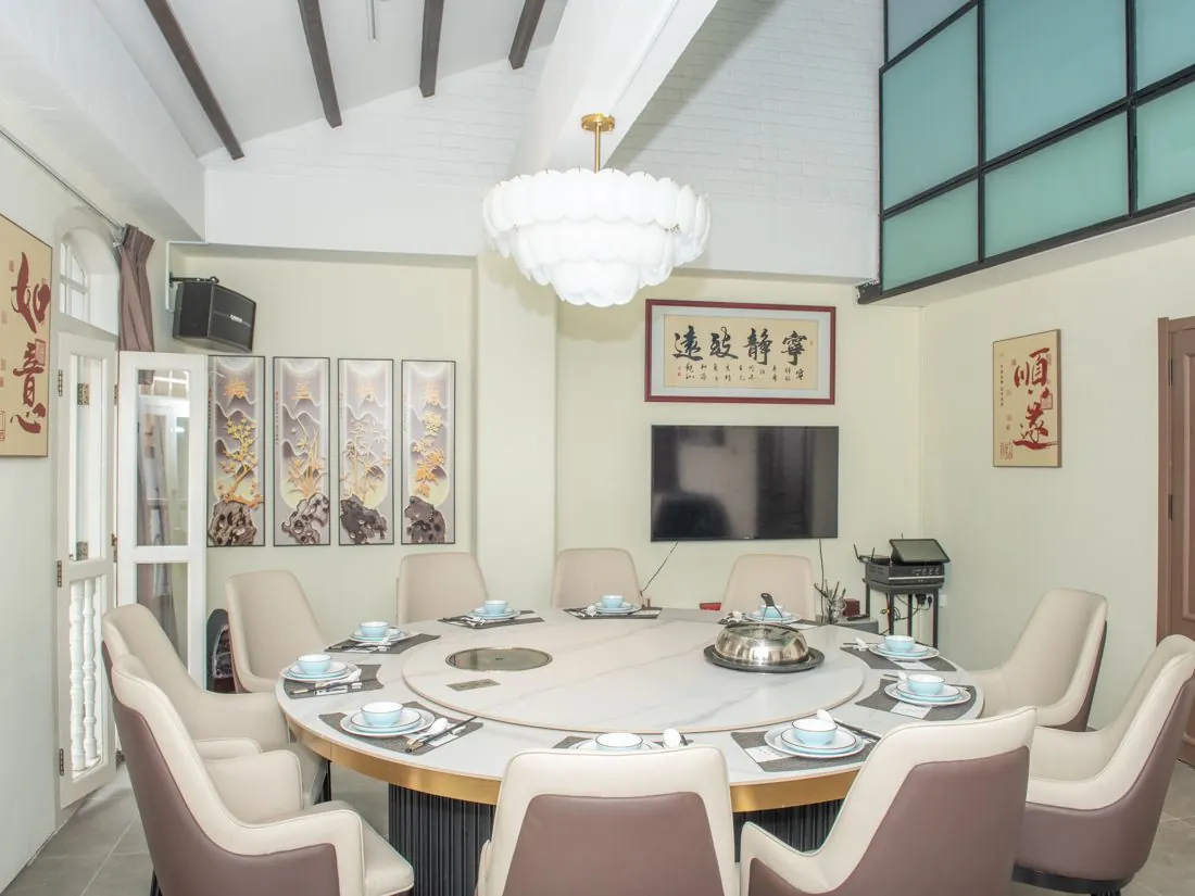 Private room with a round marble table for 12, calligraphy on the walls and a chandelier